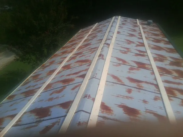 Rusted metal roof panels with new wood purlins before replacement — Storm Damage Roof Repair in Sparks by Roofing Brothers