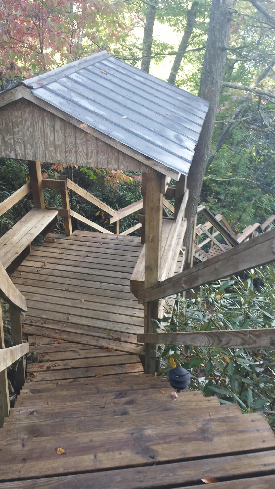Metal roofed shelter over wooden steps on a wooded walkway — Skylight Repair & Installation work by our crew in Sparks